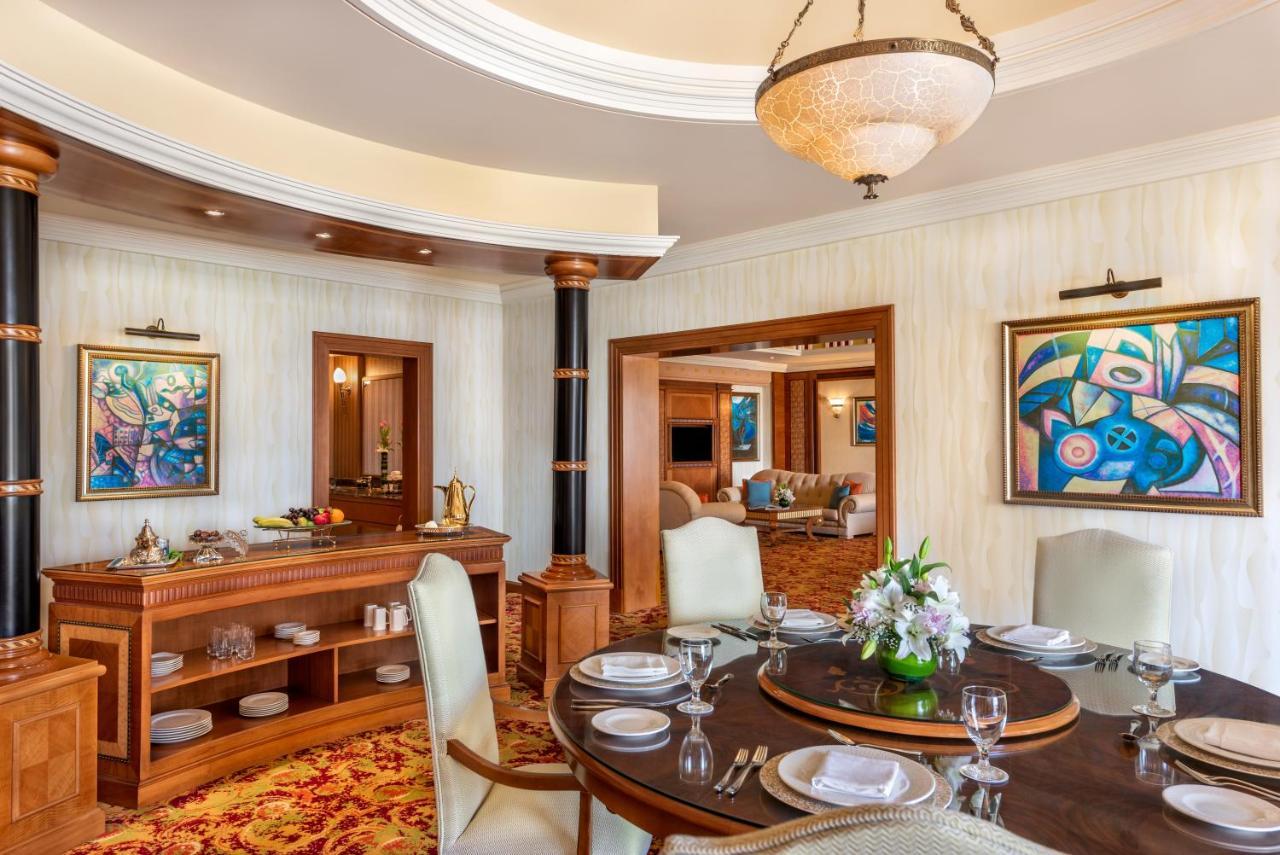 فندق شاطئ الراحة أبو ظبي المظهر الخارجي الصورة The photo shows an elegantly designed dining area and a glimpse into a luxurious living space. 

In the foreground, a round dining table is set with fine china, glassware, and a centerpiece featuring fresh flowers. The chairs surrounding the table ha
